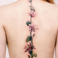 Tatuaje en la espalda, tallo trepador con flores pequeñas hermosas