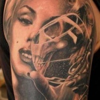 Tatuaje en el brazo, mitad cara de Marilyn Monroe mitad cráneo, diseño realista