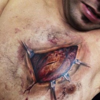 Very detailed natural looking colored ripped skin tattoo on chest with human heart