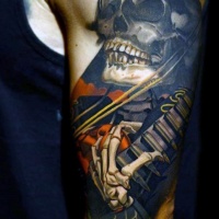 Sehr schön detailliertes und farbiges großes Skelett mit Gitarre Tattoo am Arm