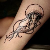 Very realistic 3D like little black ink jelly-fish tattoo on ankle