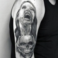 Very realistic black and white bloody vampire woman with skull tattoo on arm