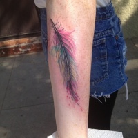 Very realistic detailed multicolored little feather tattoo on arm