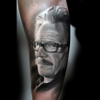 Tatuaje en el antebrazo, hombre viejo en gafas y bigotes, retrato realista