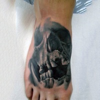Sehr realistisch aussehender schwarzer und weißer alter Schädel Tattoo am Fuß