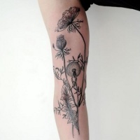 Very realistic looking black ink flowers tattoo on arm