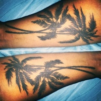 Very realistic looking black ink palm trees tattoo on arm