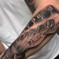 Very realistic looking detailed Fender Telecaster guitar tattoo on arm
