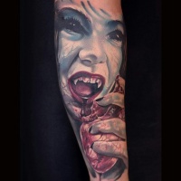 Very realistic looking multicolored woman zombie with bloody heart tattoo on sleeve