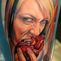 Very realistic painted and colored creepy bloody vampire woman eating humans heart tattoo on leg