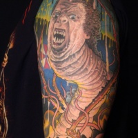 Very unusual style painted creepy half worm half man tattoo on shoulder