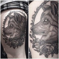 Vintage black ink demonic wolf portrait tattoo on thigh stylized with flowers
