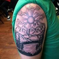 Vintage black ink lake tattoo on shoulder with mountains and sun