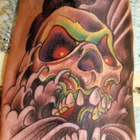 Vintage comic books style colored demonic skull tattoo on forearm with clouds