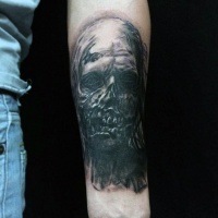 Vintage horror movie style painted forearm black ink tattoo of zombie face