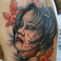 Vintage like creepy colored Asian woman severed head bloody head tattoo on shoulder with leaves