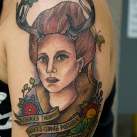 Vintage picture style colored shoulder tattoo of woman with horns and lettering