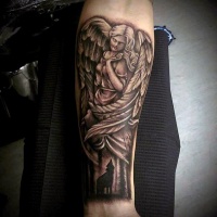 Tatuaje en el antebrazo,
estatua de ángel y lobo que aulla en el bosque