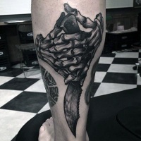 Vintage style black and white leg muscle tattoo of skeleton hand and knife
