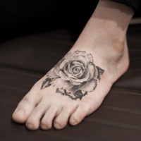 Tatuaje en el pie, rosa de colores negro blanco en estilo vintage