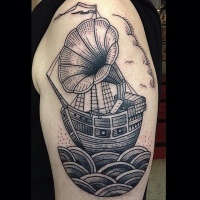 Vintage style black and white sailing ship tattoo on shoulder stylized with old gramophone