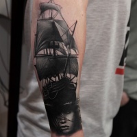 Vintage style black and white sailing ship tattoo on forearm with mystic woman portrait