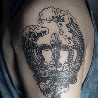 Vintage style black ink crown tattoo on shoulder with waves