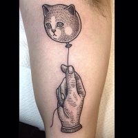 Vintage style black ink hand with cat shaped balloon on biceps