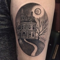 Vintage style black ink oval shaped tattoo on forearm stylized with old abandoned house