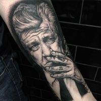Vintage style black ink smoking man portrait tattoo on forearm