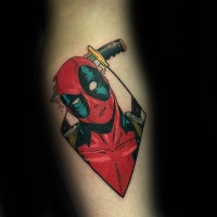 Vintage style colored forearm tattoo of Deadpool with knife in head
