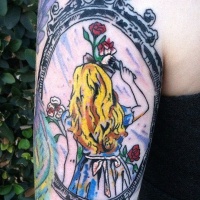 Tatuaje en el brazo, chica rubia preciosa con flores en el marco