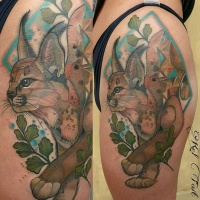 Vintage style colored thigh tattoo of young caracal with leaves
