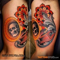 Vintage style multicolored gramophone tattoo on biceps stylized with ornamental flower and skull
