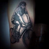 Vintage style painted black and white man on bicycle tattoo on arm