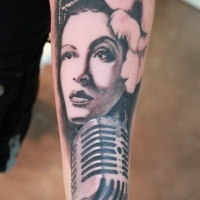 Vintage style painted black and white woman portrait tattoo on forearm with mycrophone
