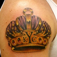 Violet and golden crown tattoo on shoulder