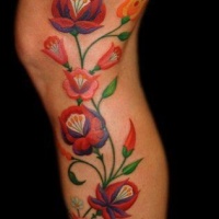 vivaci colori bellissimi fiori tatuaggio sulla gamba
