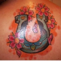 Vivid colors horseshoe and red and orange flowers tattoo