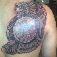 Warrior in indian headdress and with a shield tattoo on shoulder blsde
