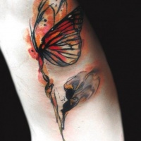 Tatuaggio colorato la farfalla incantevole sul fiore