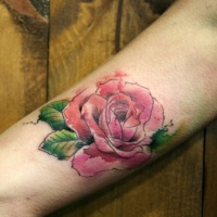 Watercolor like painted big rose tattoo on arm