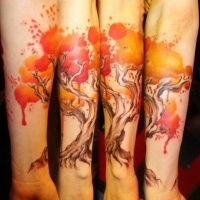 Tatuaje en el antebrazo, árbol con hojas naranjas