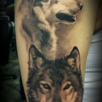 Aquarell-Porträt der zwei Wölfe Tattoo an der Schulter