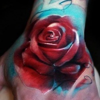 Tatuaje en la mano, rosa roja con azul luz