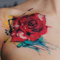 Tatuaje en el pecho, rosa acuarela con manchas amarilla y azul