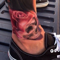 Tatuaje de cráneo y rosa en el tobillo