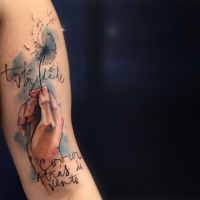 Watercolor style colored arm tattoo of human hand with lettering and flower