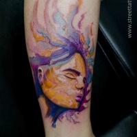 Watercolor style colored arm tattoo of woman face