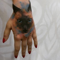 Watercolor style colored hand tattoo of cat face